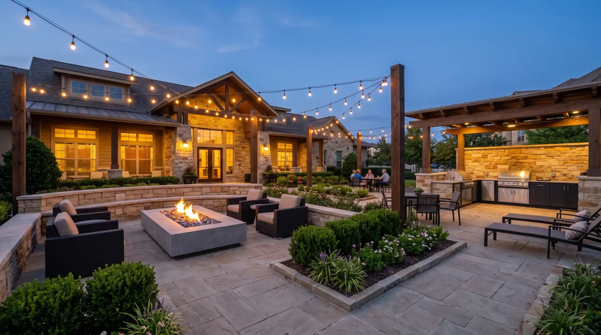 A clubhouse patio at dusk, with string lights, a fire table and lounge seating